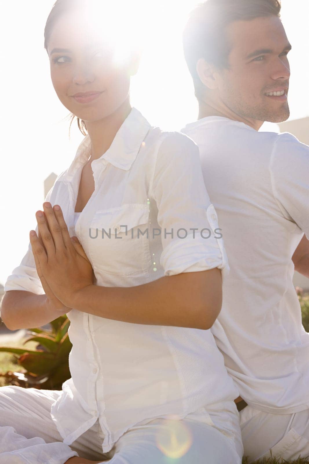 Her minds always on him. a young man and woman doing yoga outdoors