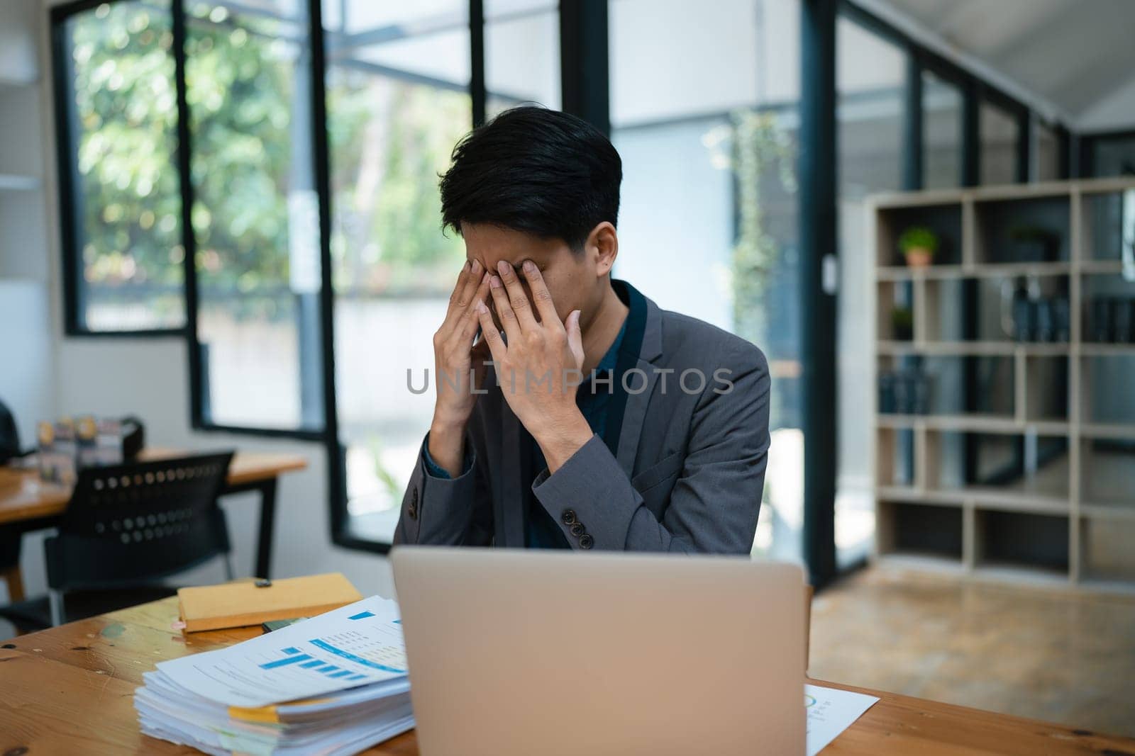 Portrait of business owner, man using computer and financial statements Anxious expression on expanding the market to increase the ability to invest in business
