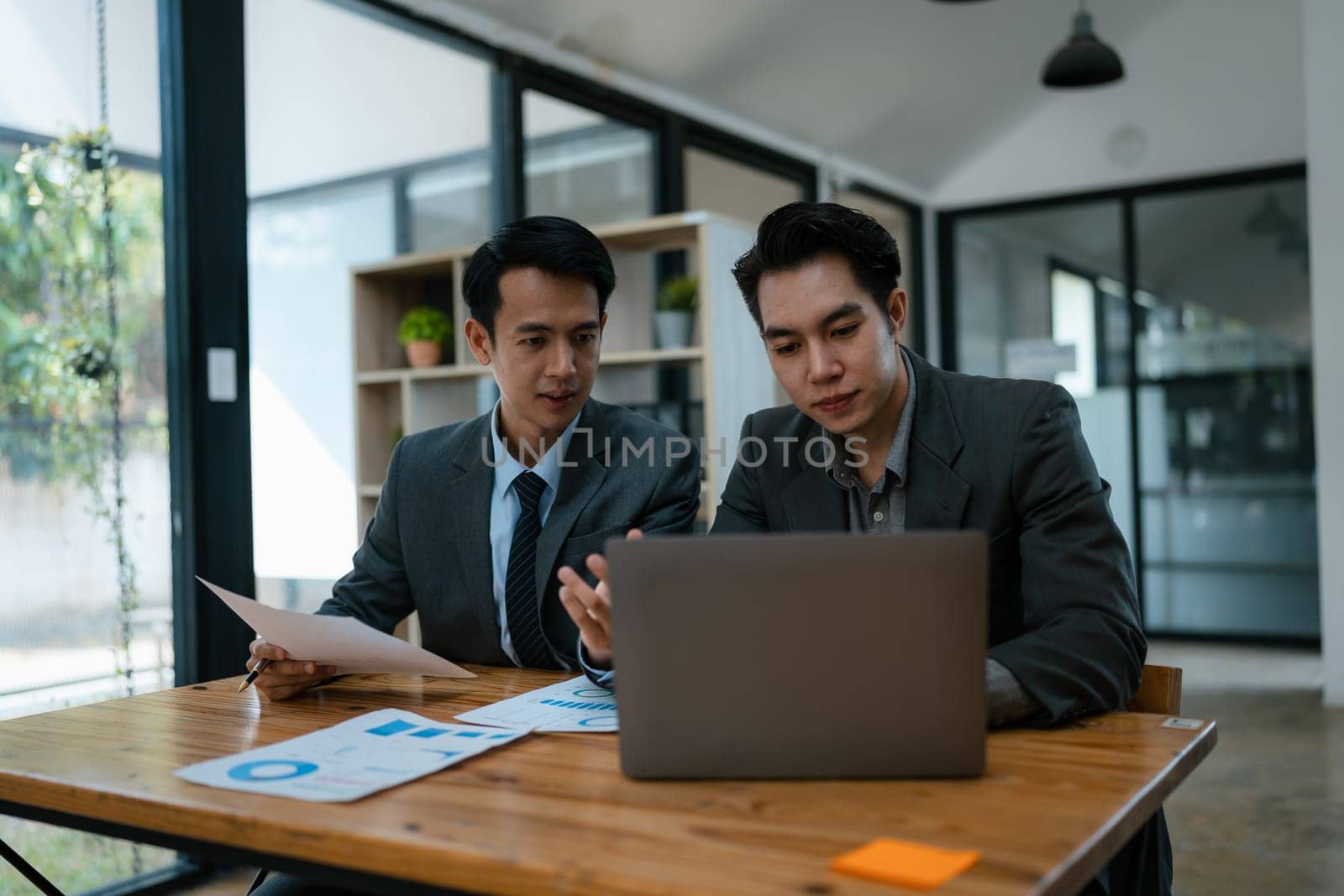 startup business, business advisor explaining strategy for planning finance investment teamwork paperwork audit and discussing marketing, profit, budget of company in meeting room. by Manastrong