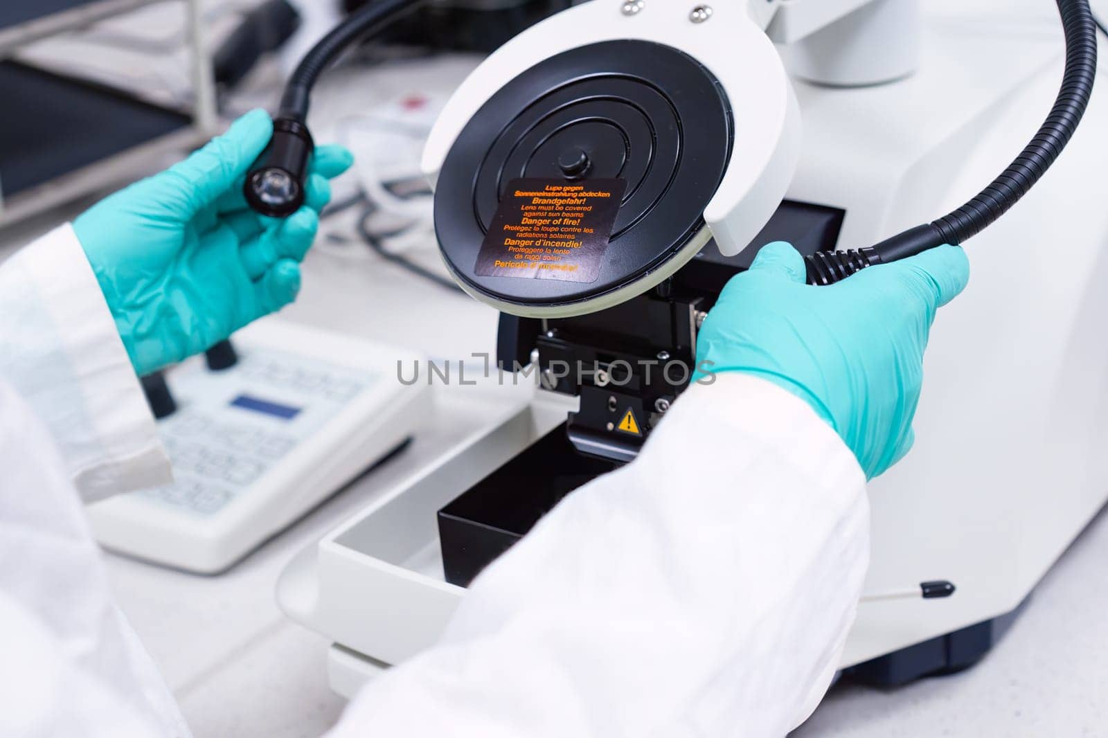 Scientist inserts lamps of microscope for focusing on a specimen.