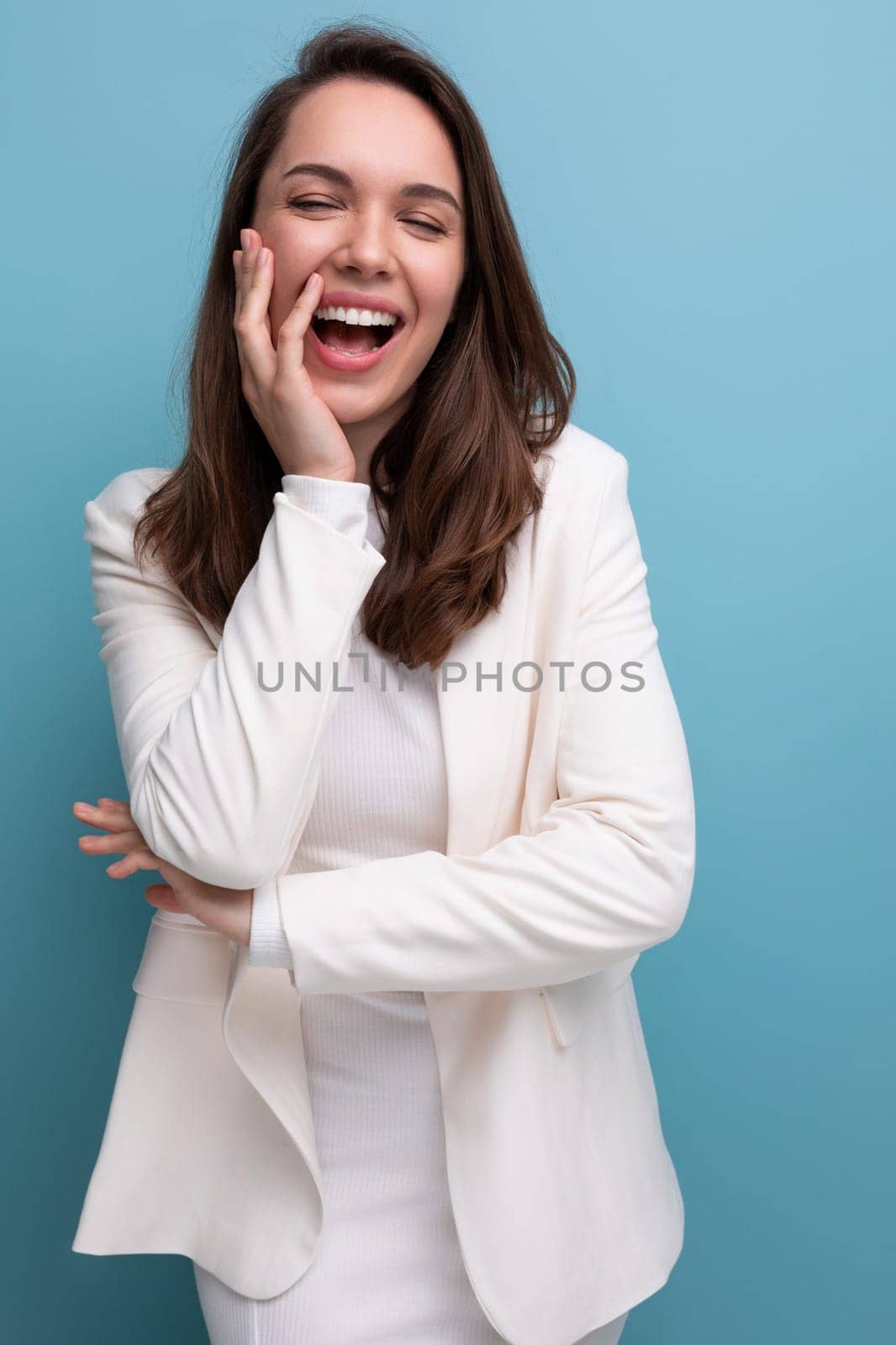 pleasant european brunette young woman in a white dress with cheerful emotions on her face.