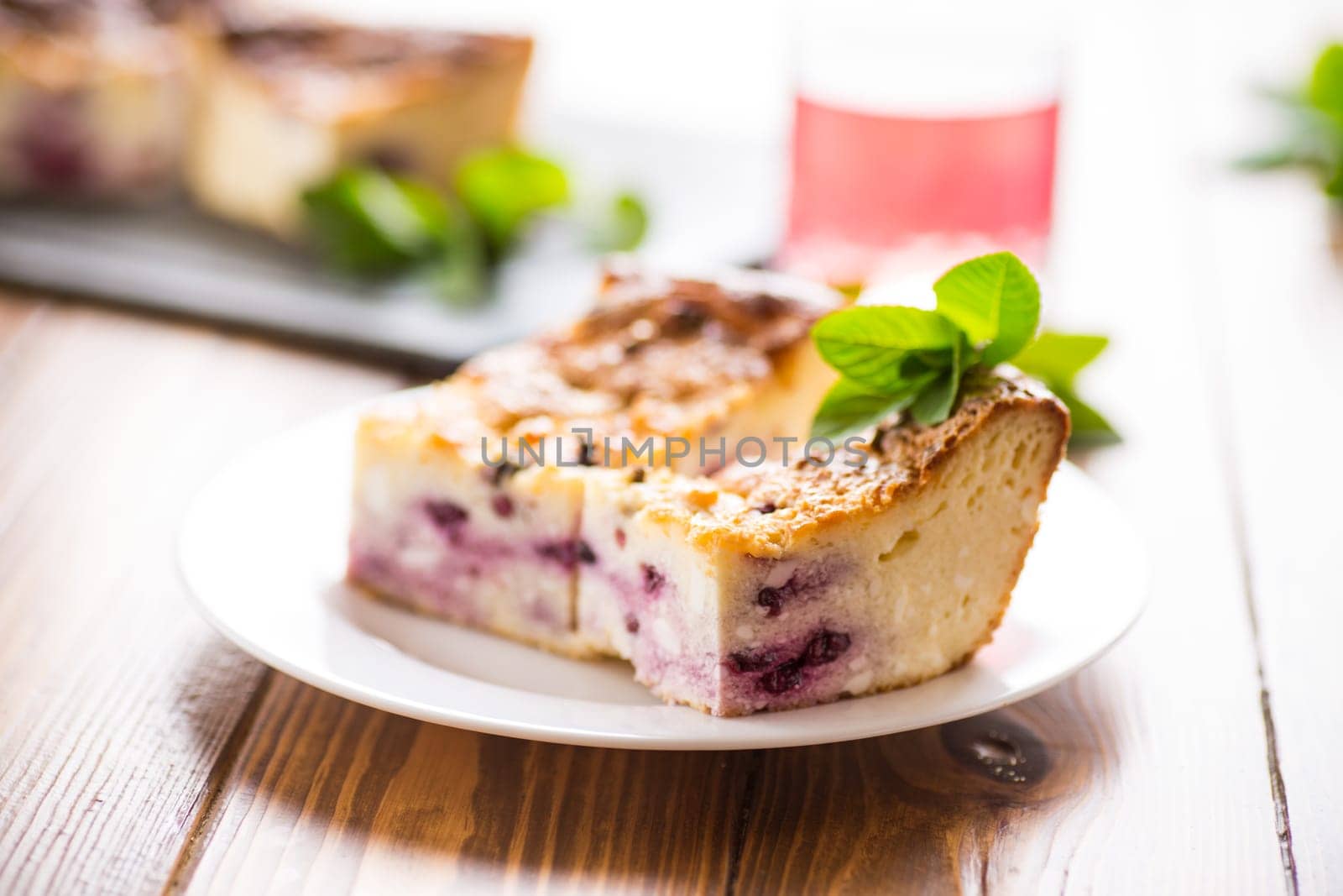 cooked cottage cheese casserole with berry filling in a plate on the table