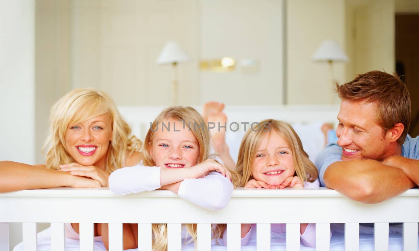 Happy family lying in bed together. Portrait of a happy family lying in bed together. by YuriArcurs