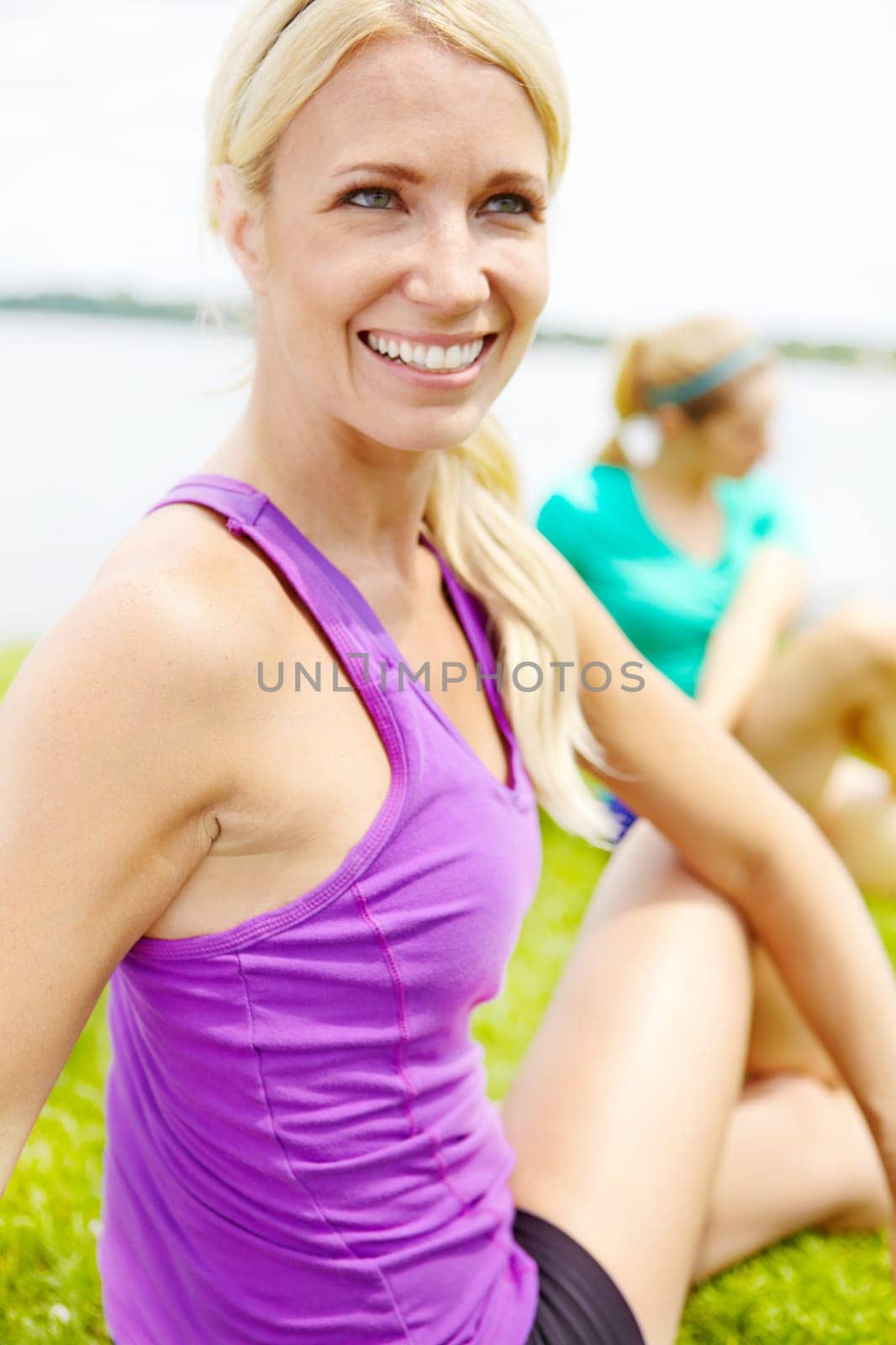 Post-race stretching. Close up of a female athlete looking away from the camera while stretching outdoors. by YuriArcurs