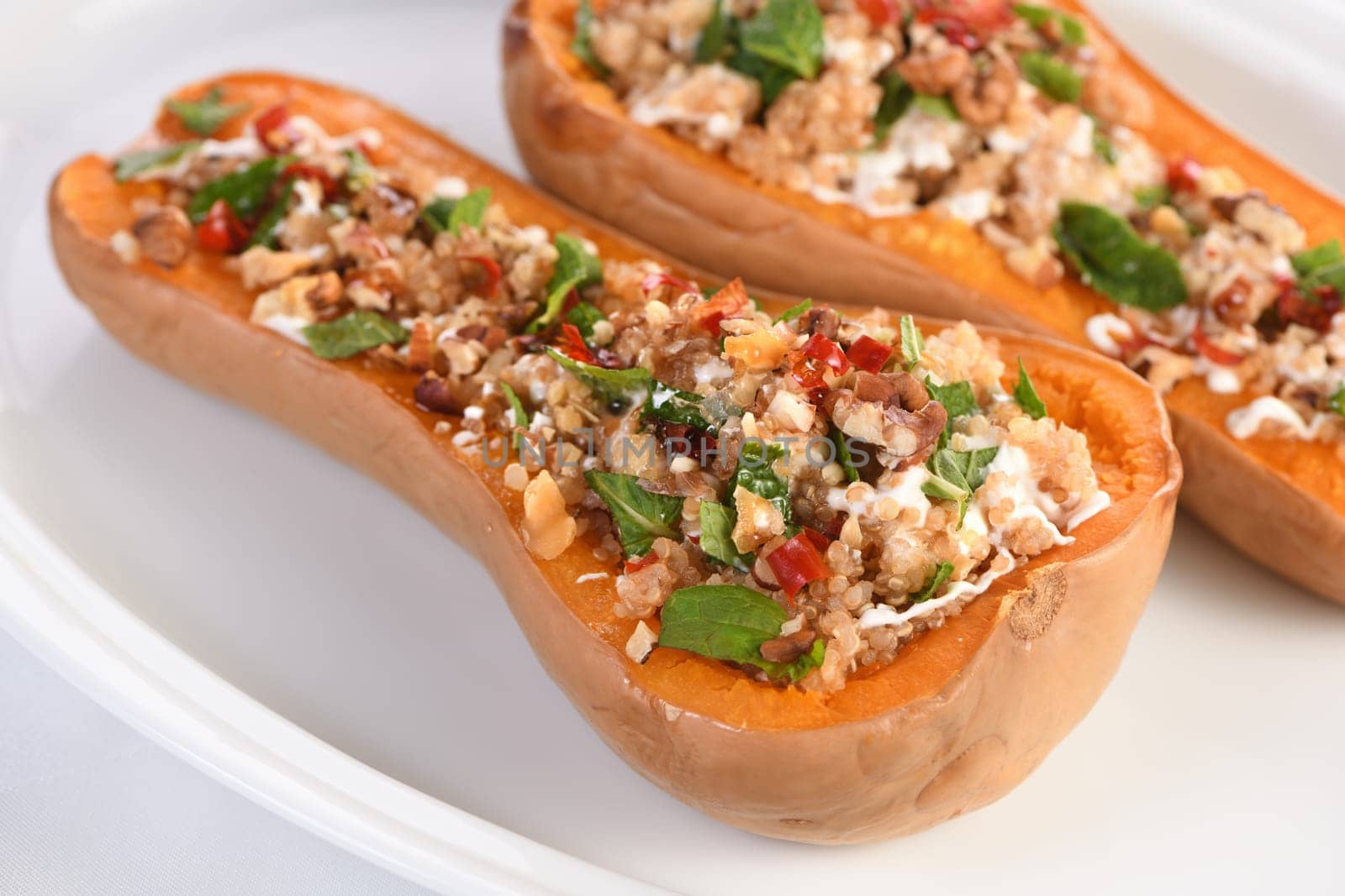 Baked stuffed pumpkin filled with walnuts, fresh mint and chili with quinoa tabbouleh. The maple syrup makes them excellent. It is a healthy side dish or main dish for vegans and paleo.