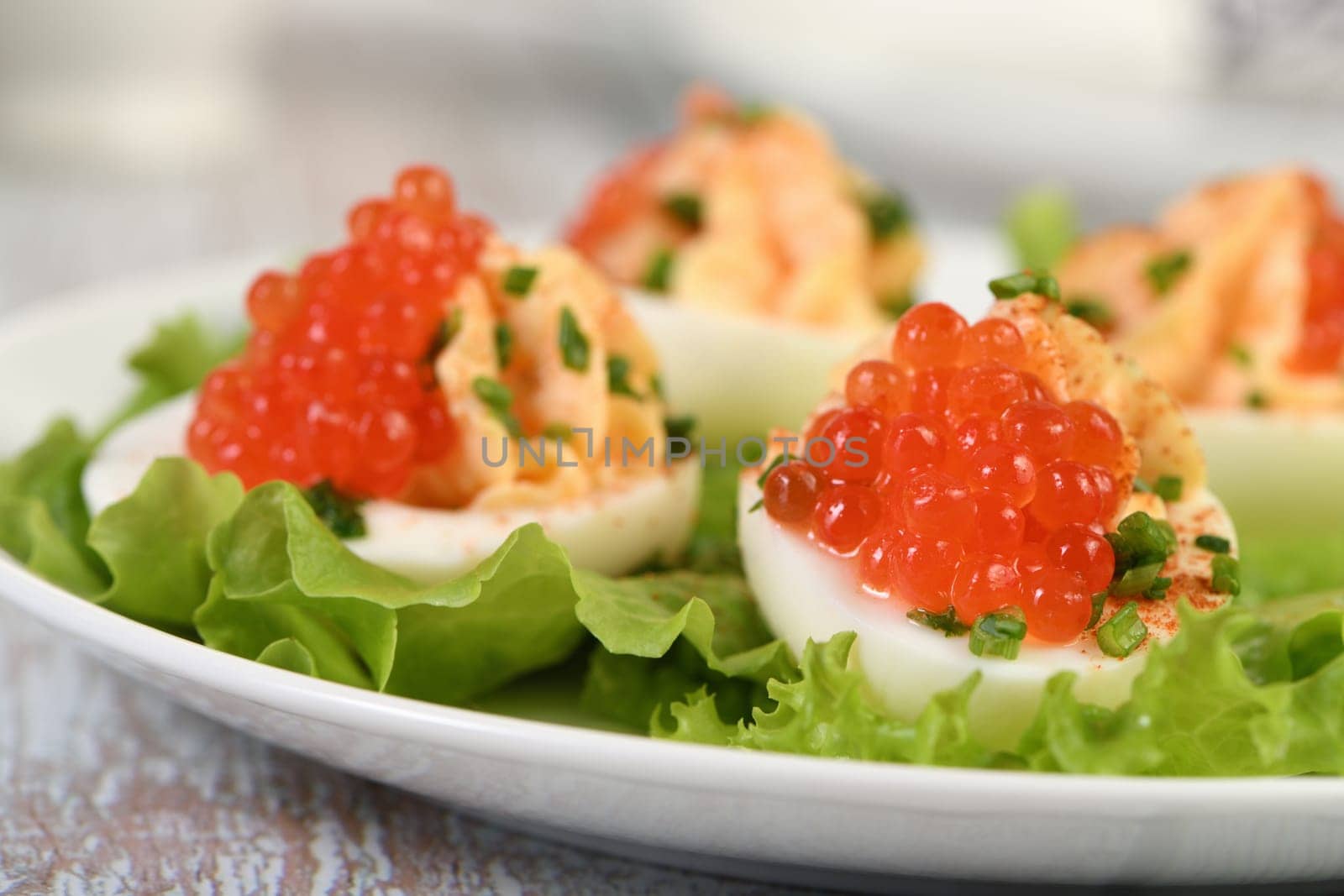 Stuffed eggs with salmon caviar are a popular appetizer for any occasion. Elegantly decorated and expertly seasoned, they will always be a beautiful appetizer at a party.