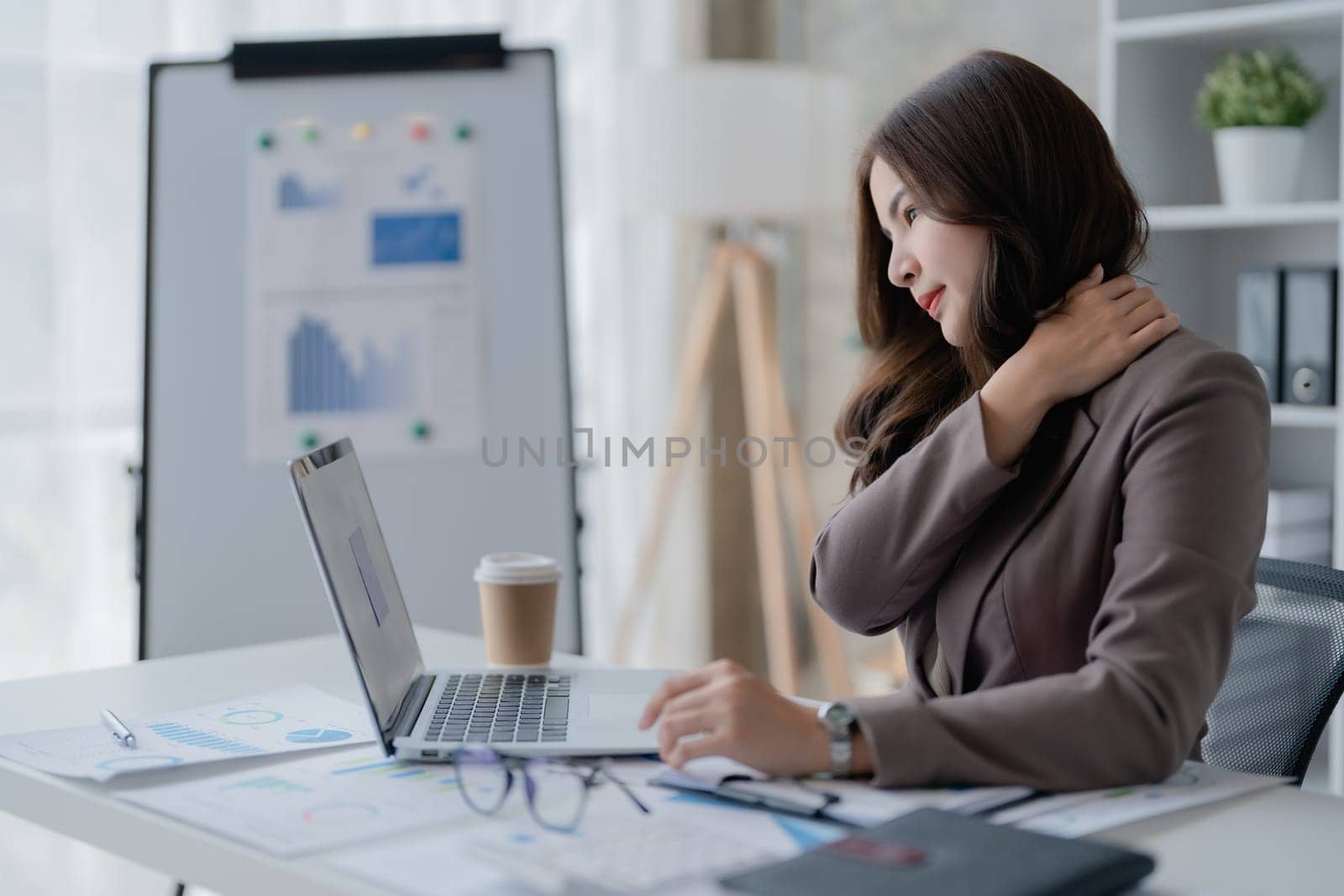 Portrait of a young Asian woman suffering from acute headache and occipital pain from sitting for a long time at work