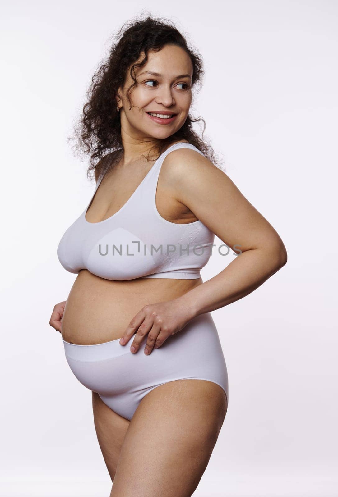 Charming pregnant woman posing bare belly in lingerie white background by artgf