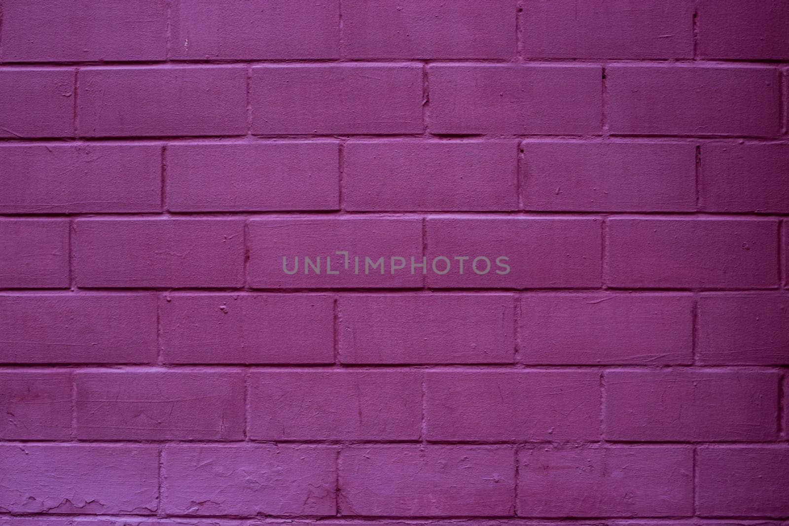 Painted brick wall in pink purple paint texture stone background.