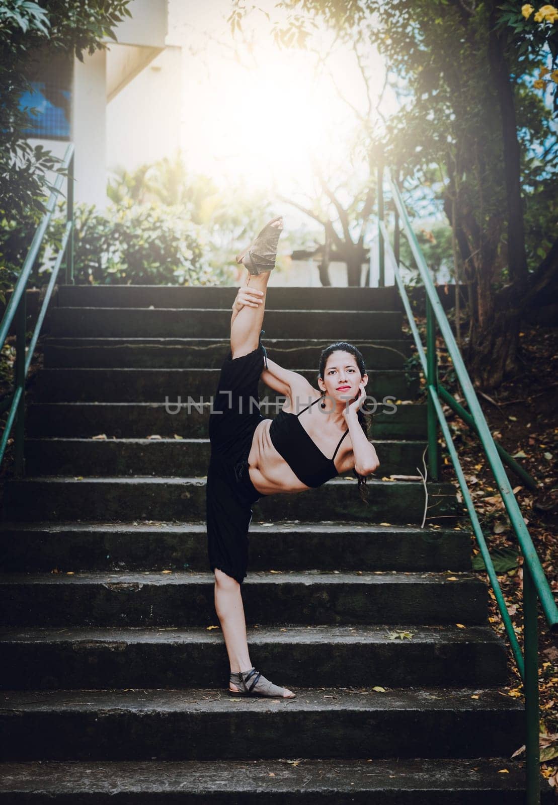 Dance artist girl doing acrobatics and flexibilities in heels. Dance girl doing flexibility on the stairs outdoor. Portrait of woman dancer in heels doing yoga flexibilities by isaiphoto