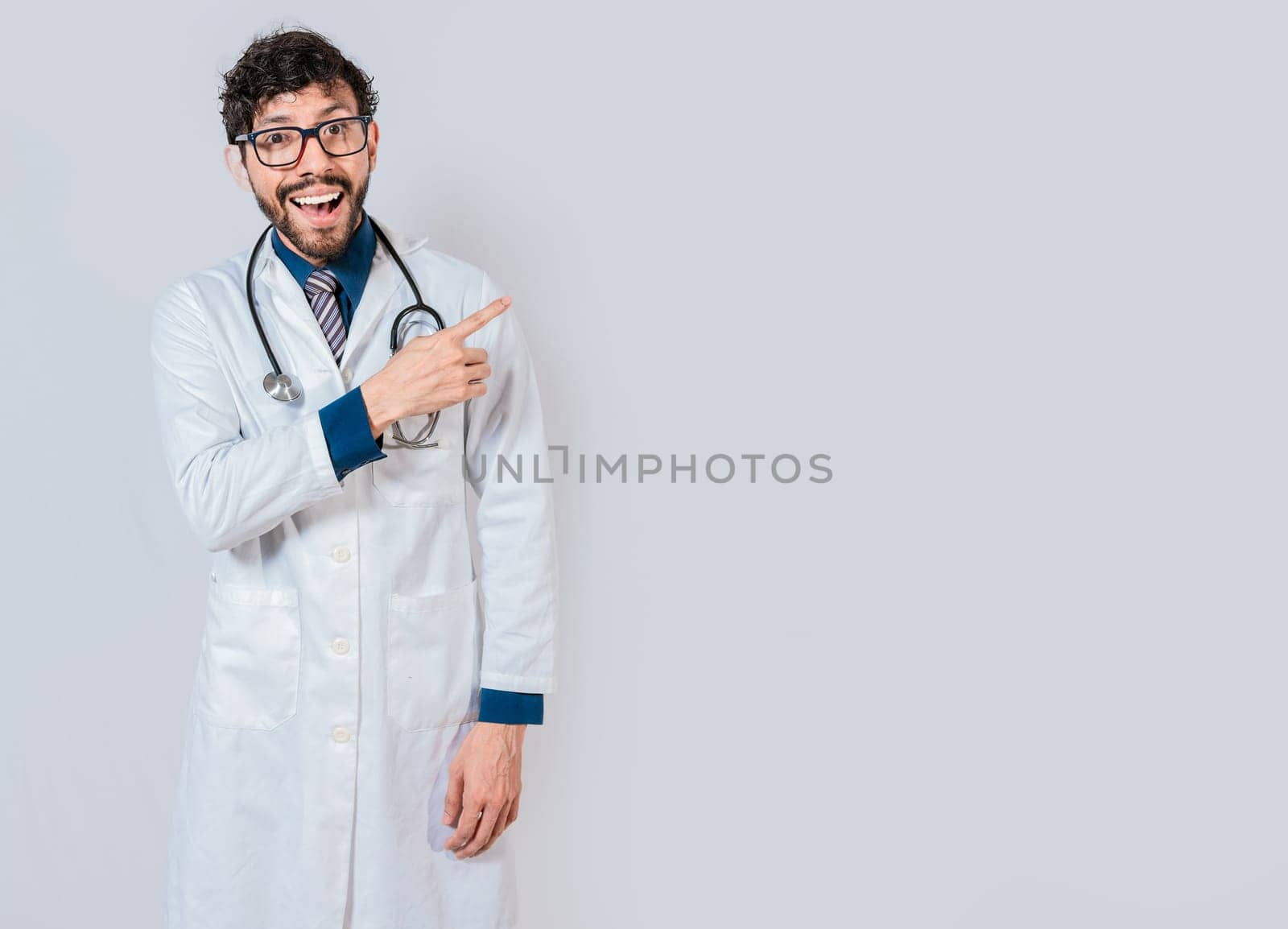 Young doctor pointing a promotion with  finger. Happy doctor pointing at advertising space isolated. Happy doctor pointing right with finger