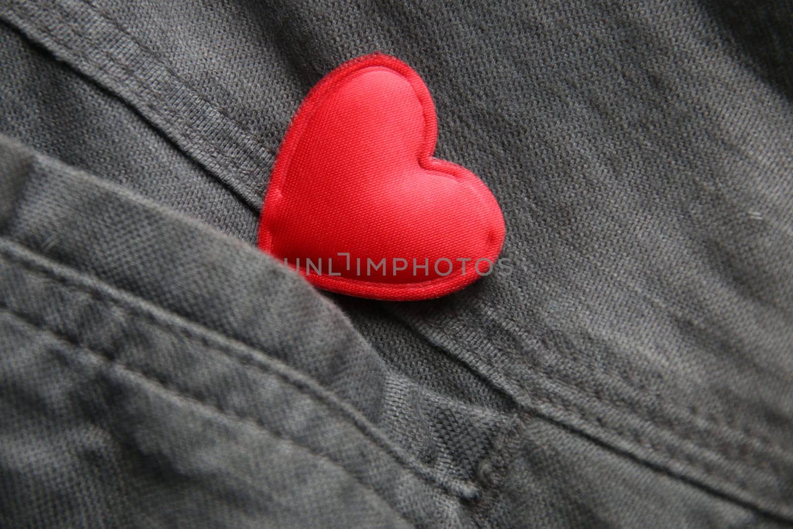 Valentine card, creative concept. Red heart in jeans pocket.