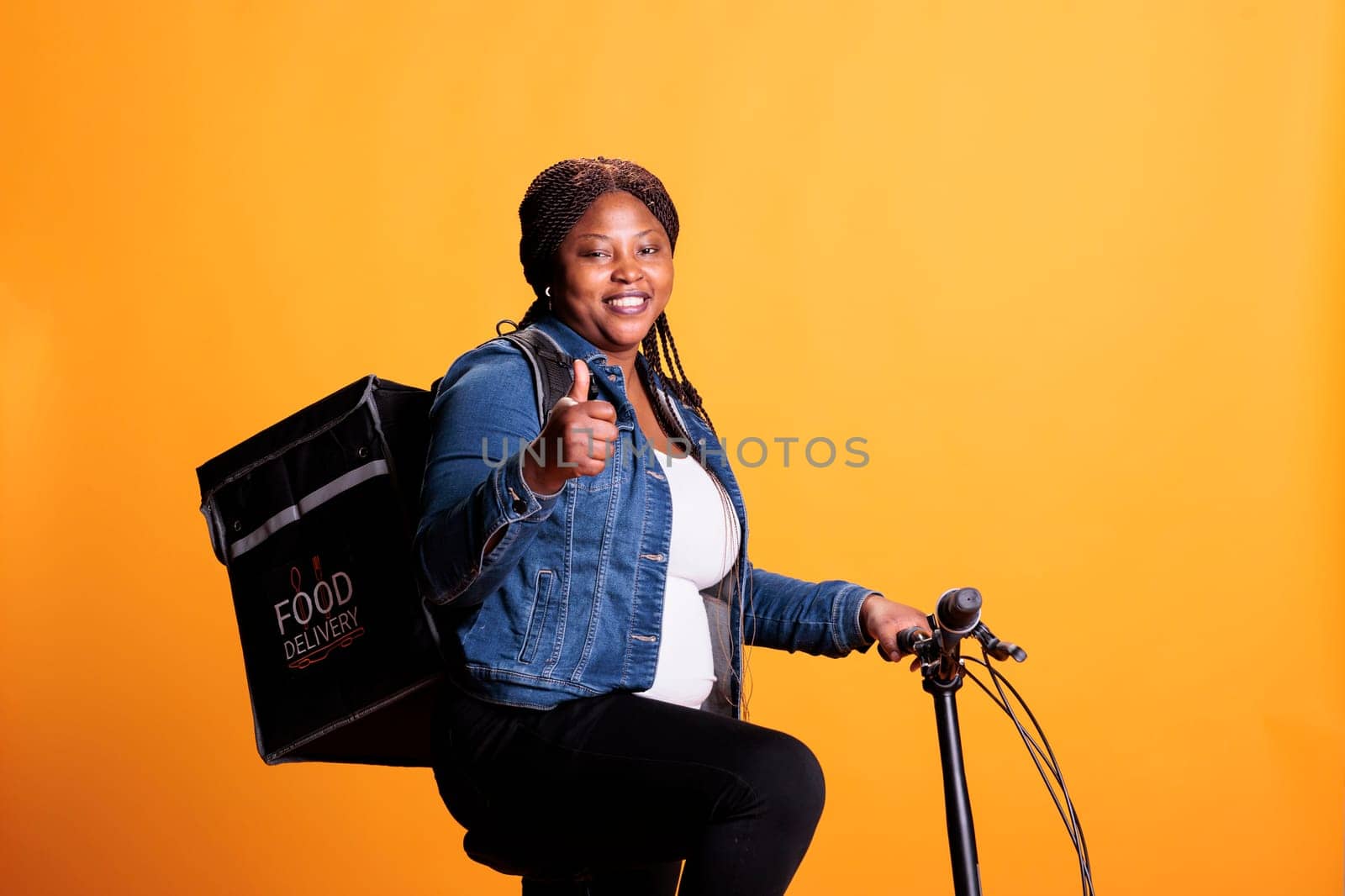Positive african american courier carrying thermal takeaway backpack doing thumbs up gesture by DCStudio