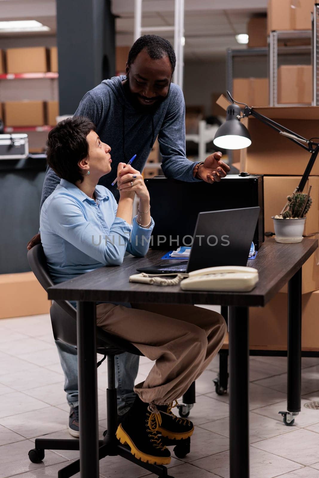 Employees looking at transportation logistics on laptop computer analyzing delivery checklist by DCStudio