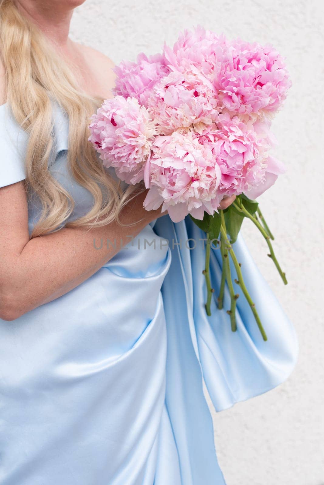 bride in a blue wedding dress with a bouquet of pink peonies, pastel paradise, floral background, complementary color combination. High quality photo