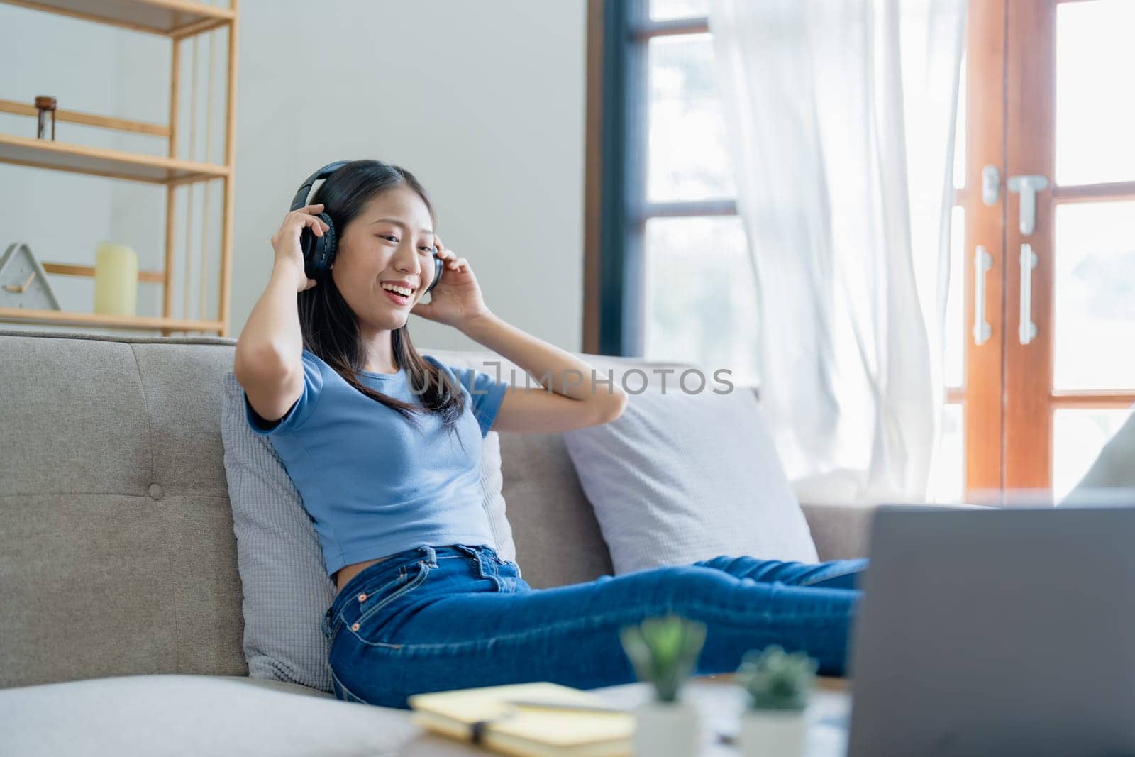 Home lifestyle woman relaxing sleeping on sofa patio living room. Happy lady lying down on comfortable pillows taking a nap for wellness and health. Tropical vacation