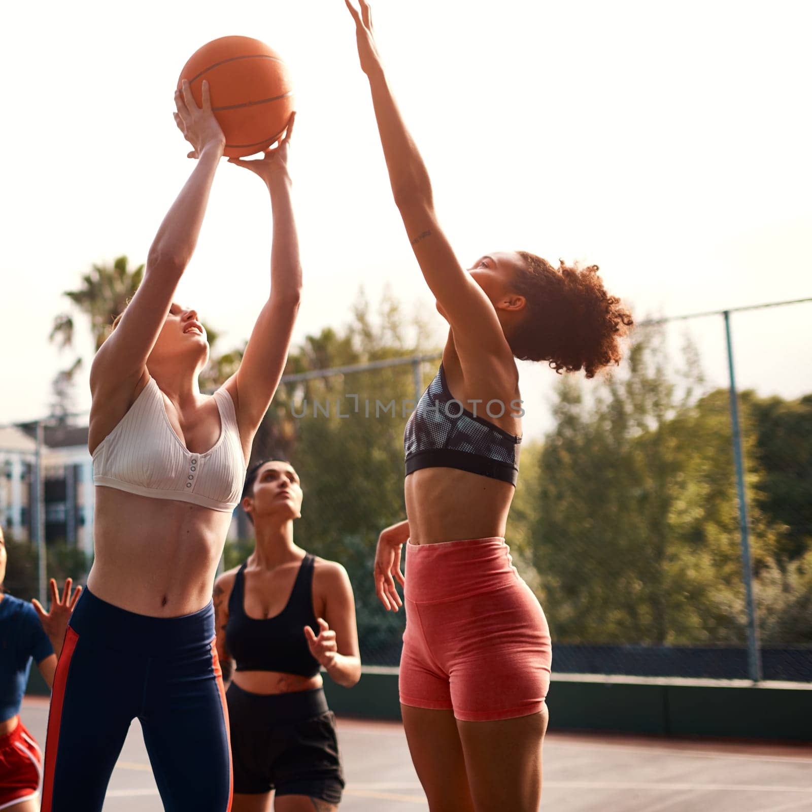 Trying my luck here. a diverse group of sportswomen playing a competitive game of basketball together during the day. by YuriArcurs