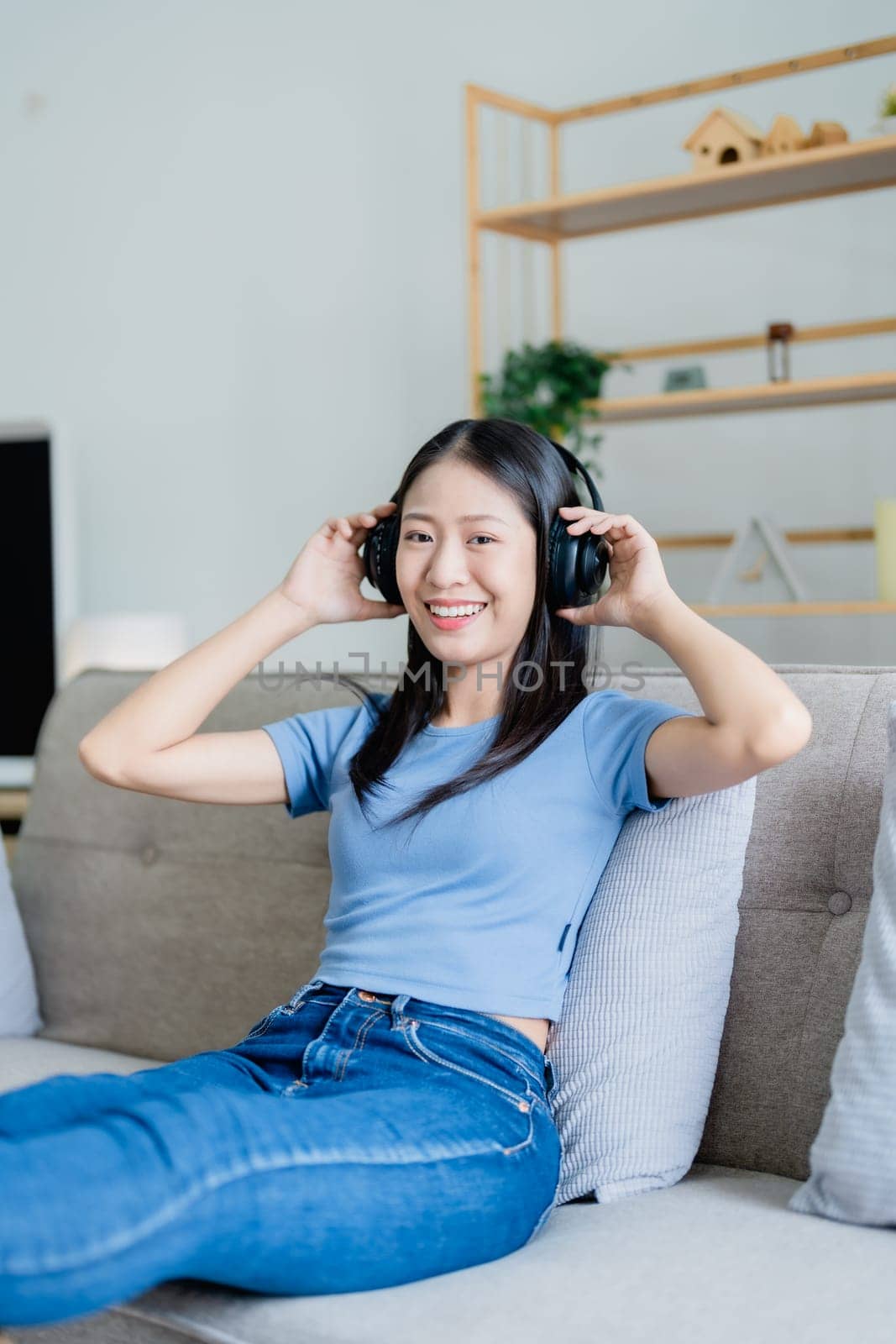 Home lifestyle woman relaxing sleeping on sofa patio living room. Happy lady lying down on comfortable pillows taking a nap for wellness and health. Tropical vacation. by Manastrong