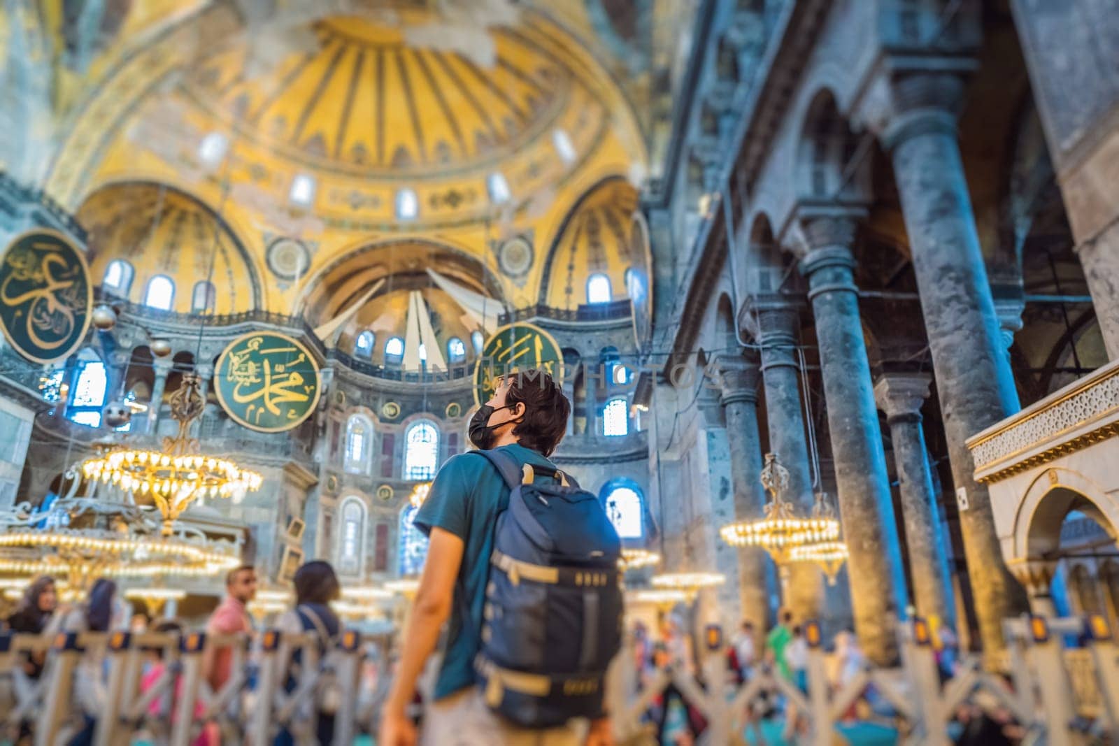 Man tourist enjoying Hagia Sofia, Ayasofya interior in Istanbul, Turkey, Byzantine architecture, city landmark and architectural world wonder. Turkiye.