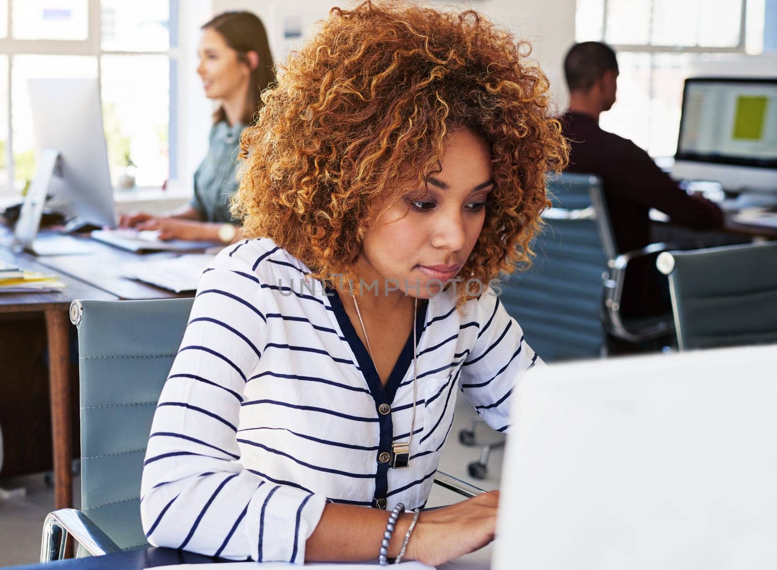 Black woman serious in startup and typing on laptop in modern office as copywriter or journalist, creative and content research. Wifi, busy female and productivity with copywriting at media company.