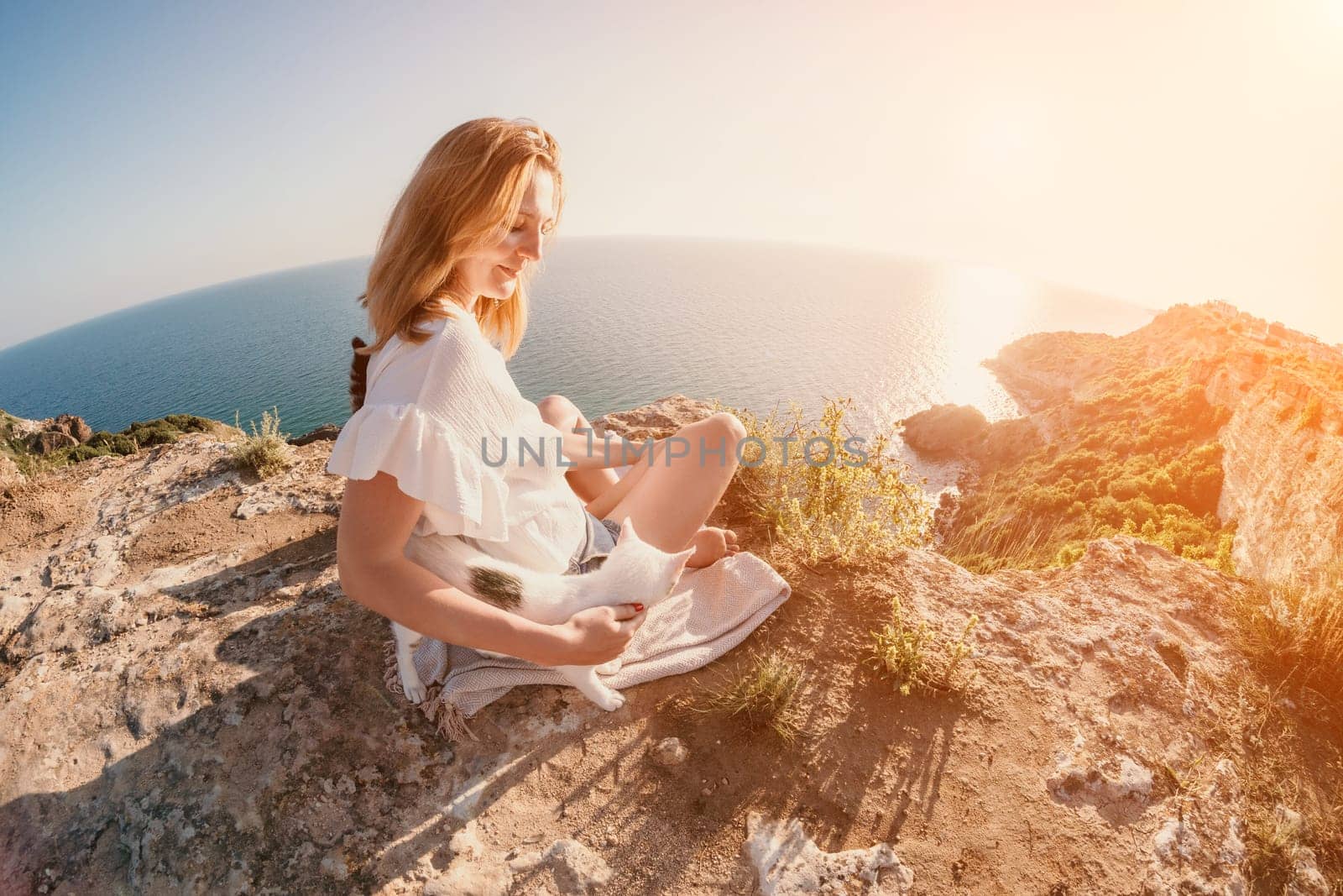 Woman sea laptop. Business woman petting cat and working on laptop by the sea. Close up on hands of pretty lady typing on computer outdoors summer day. Freelance, digital nomad and holidays concept. by panophotograph