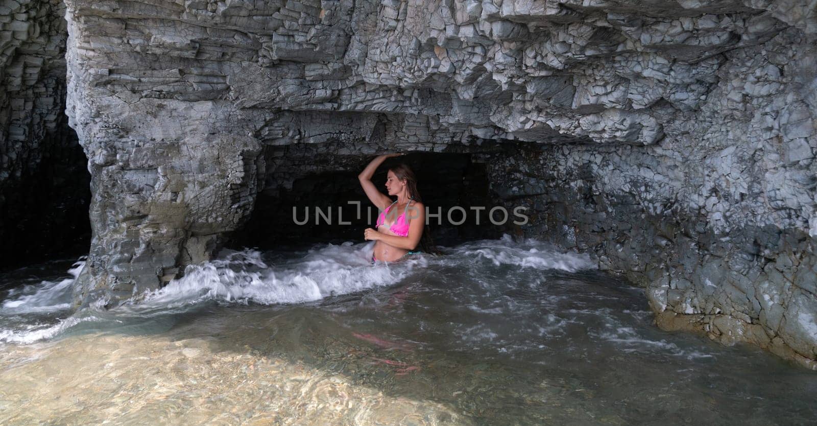 Woman travel sea. Happy tourist in pink bikini enjoy taking picture outdoors for memories. Woman traveler posing on the beach at sea surrounded by volcanic mountains, sharing travel adventure journey by panophotograph