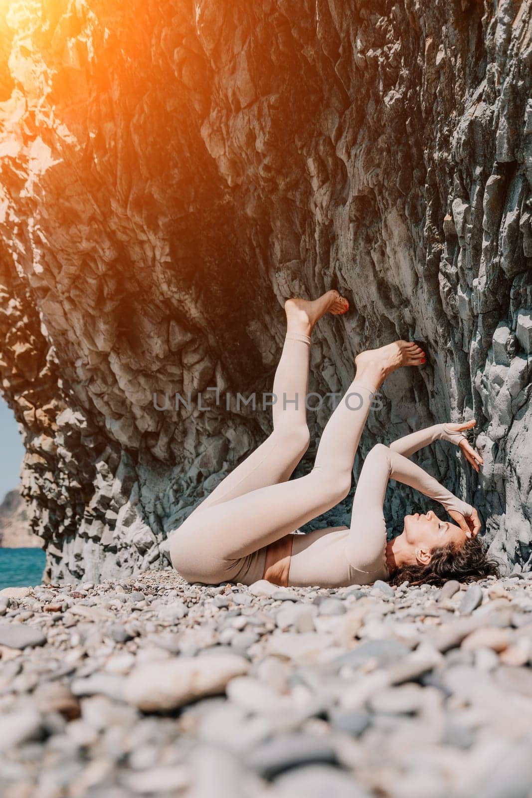 Woman travel sea. Sporty happy middle aged posing on a beach near the sea on background of volcanic rocks, like in Iceland, sharing travel adventure journey by panophotograph