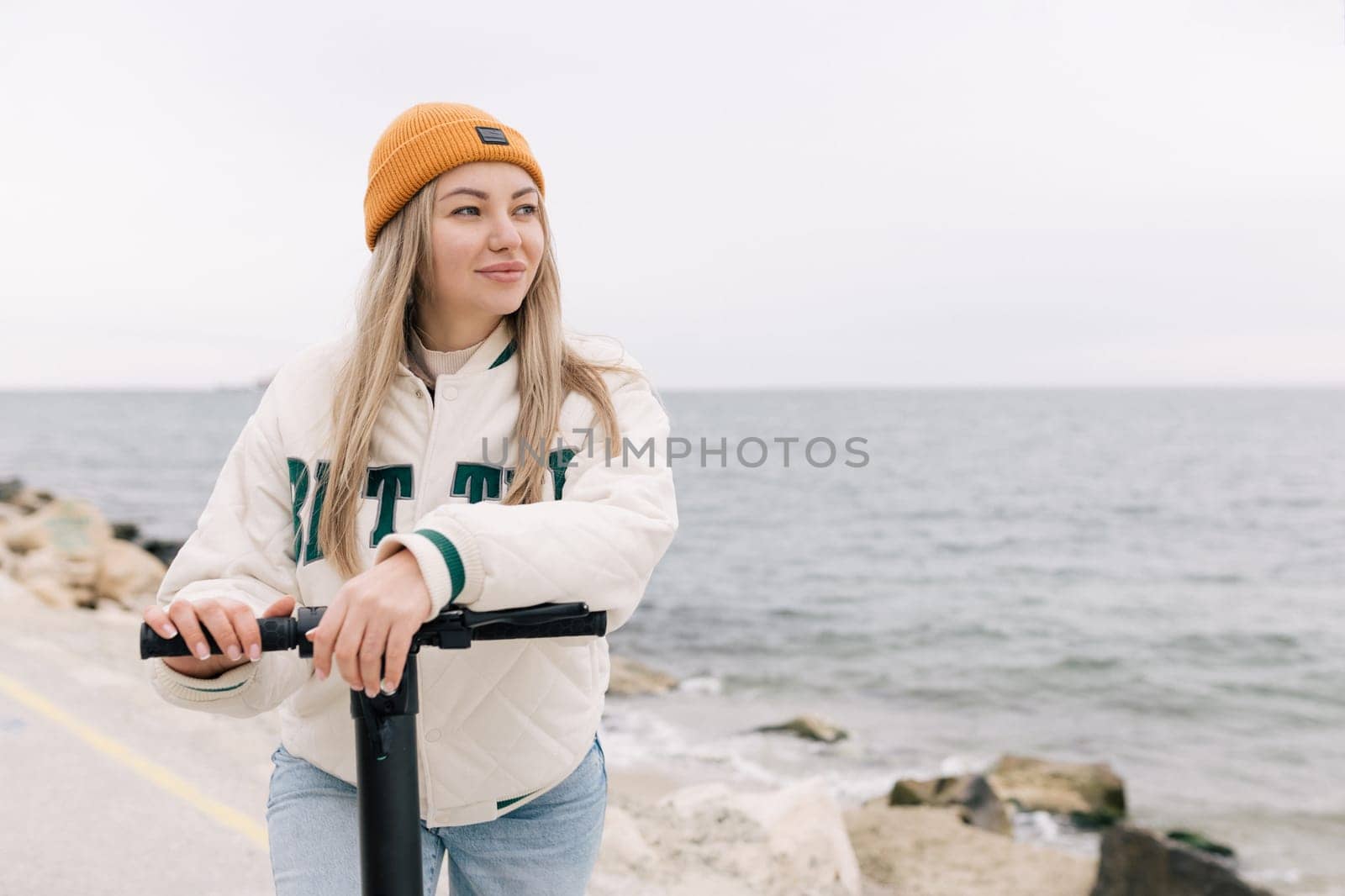 Milan, Italy - February 21, 2018: Attractive girl riding an electric scooter along the promenade in Europe.