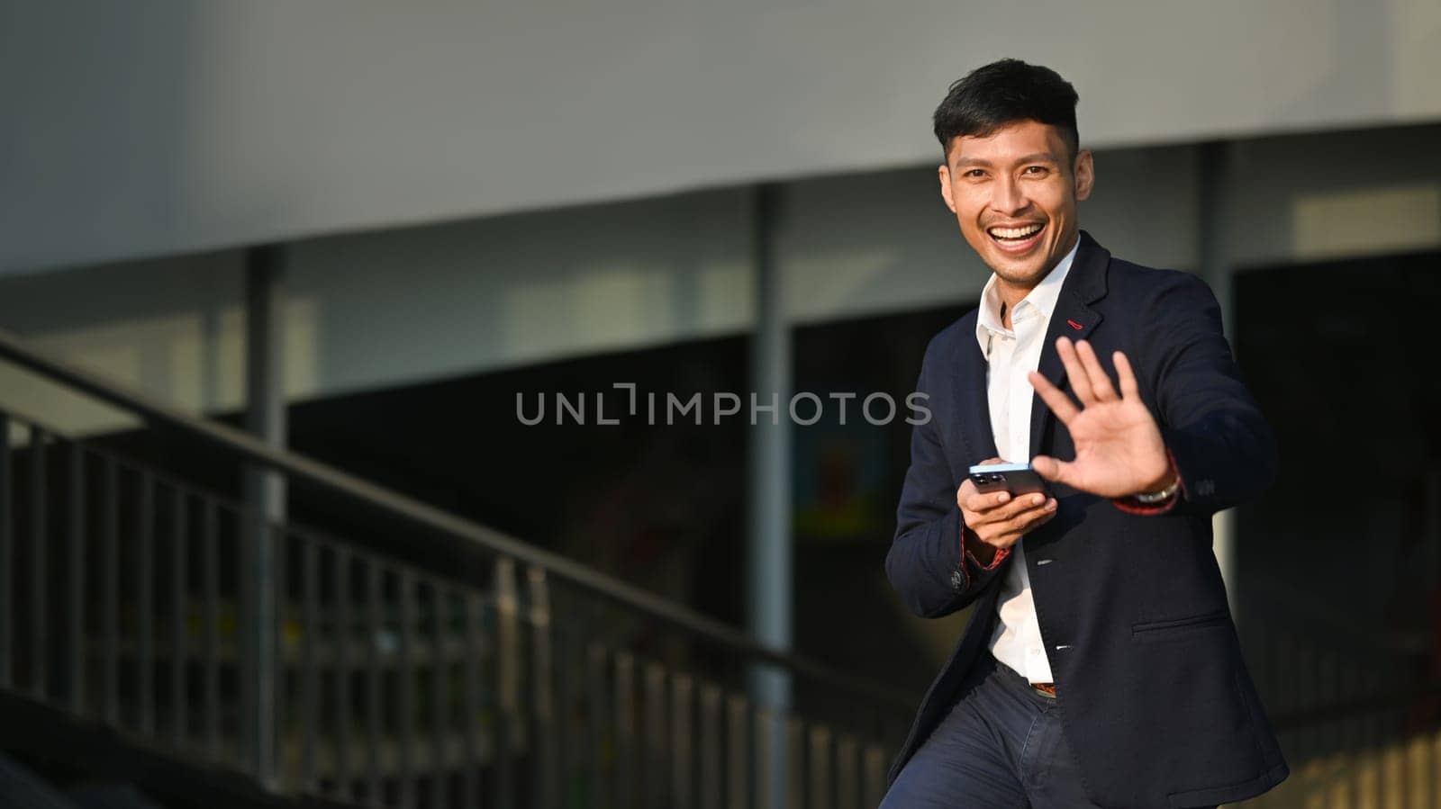 Shot of businessman using smartphone while walking in business district. Modern lifestyle, technology and business concept.
