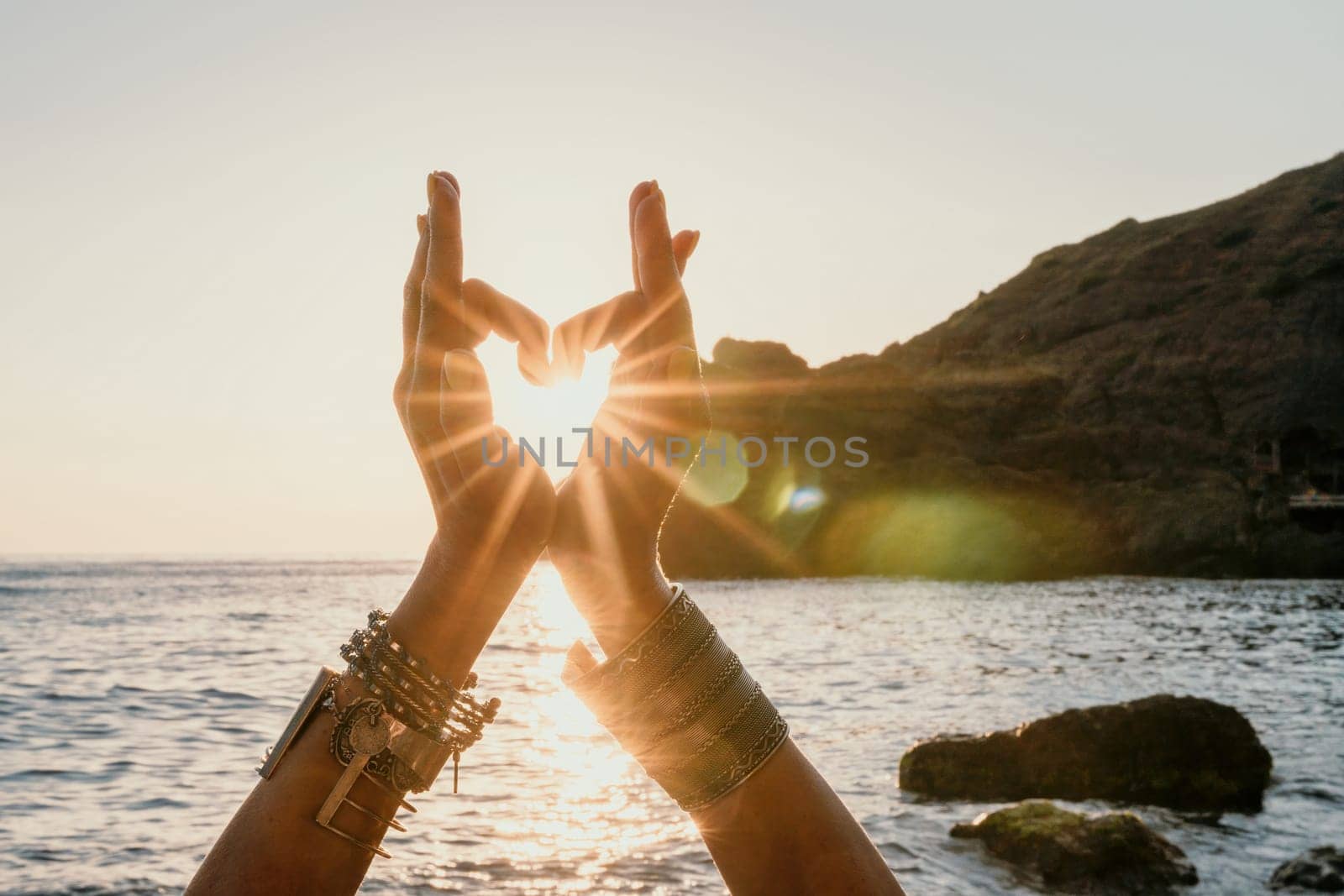 Young woman in swimsuit with long hair practicing stretching outdoors on yoga mat by the sea on a sunny day. Women's yoga fitness pilates routine. Healthy lifestyle, harmony and meditation concept.