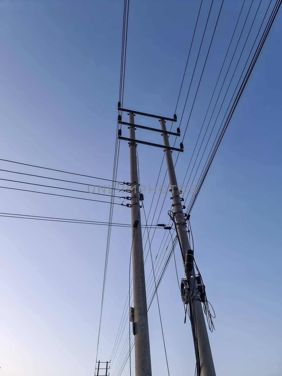 Wildly attached power cables to a power pole with a blue sky by MP_foto71