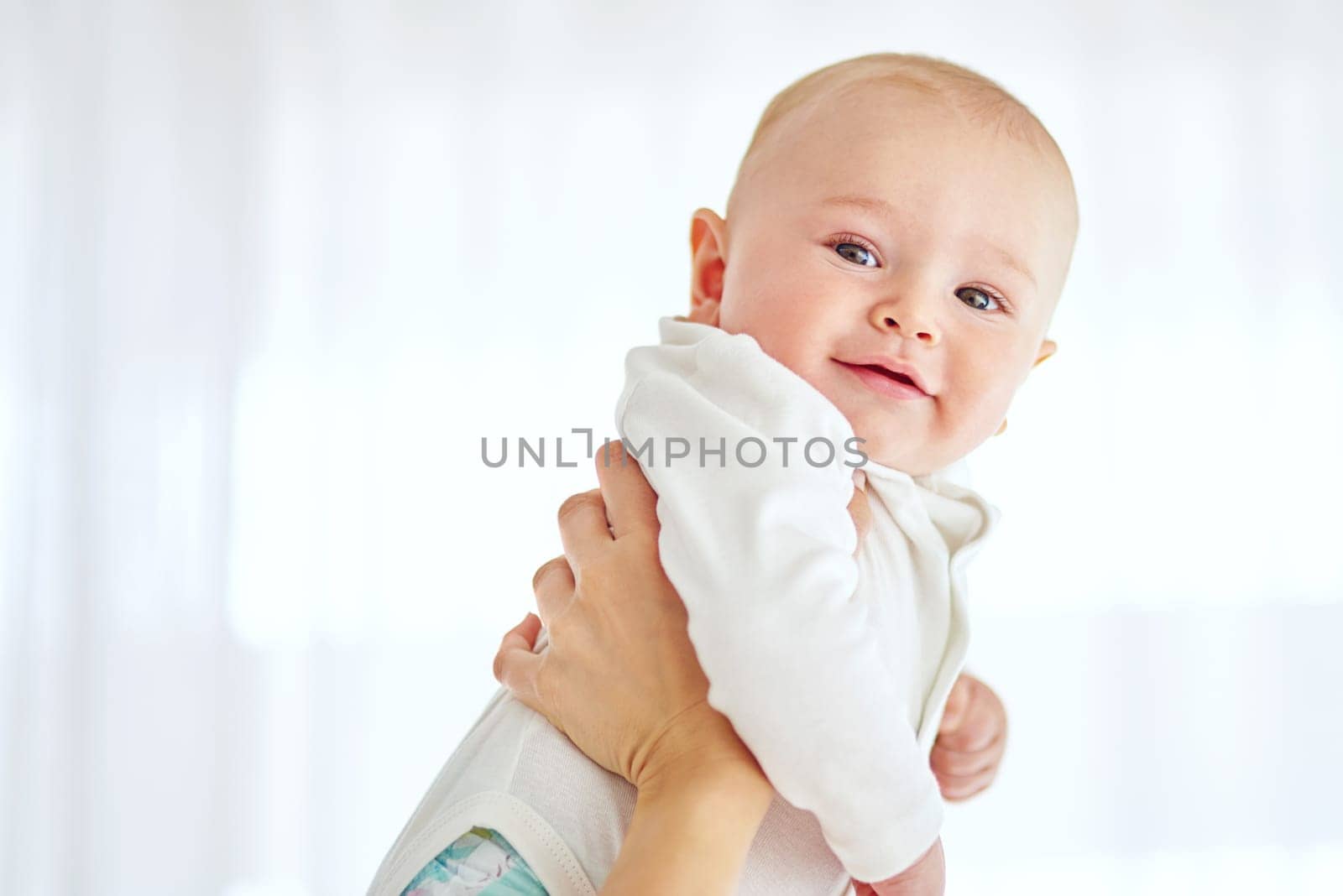 Cropped shot of a baby boy being held by his parent at home.