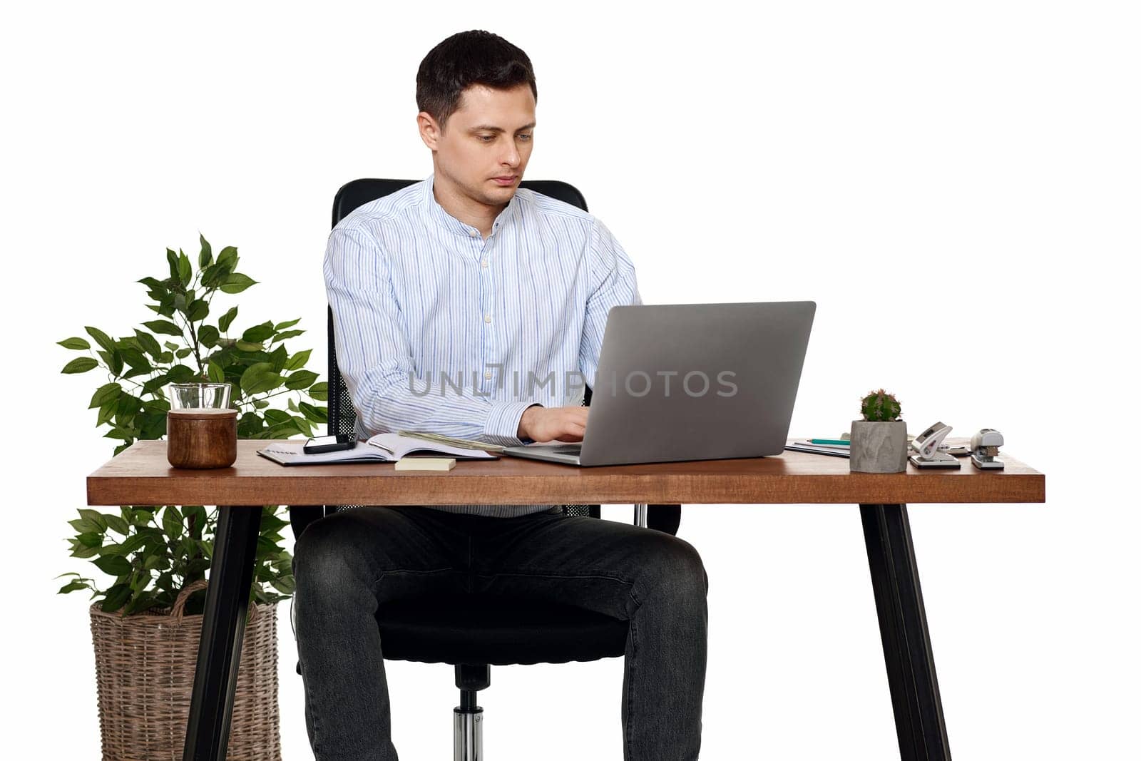 young man using laptop computer for online work at table on white background