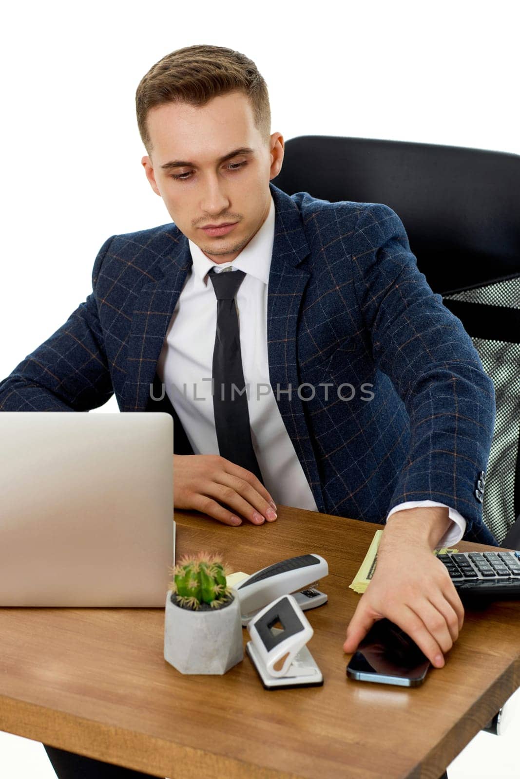 handsome businessman working with laptop and using smartphone