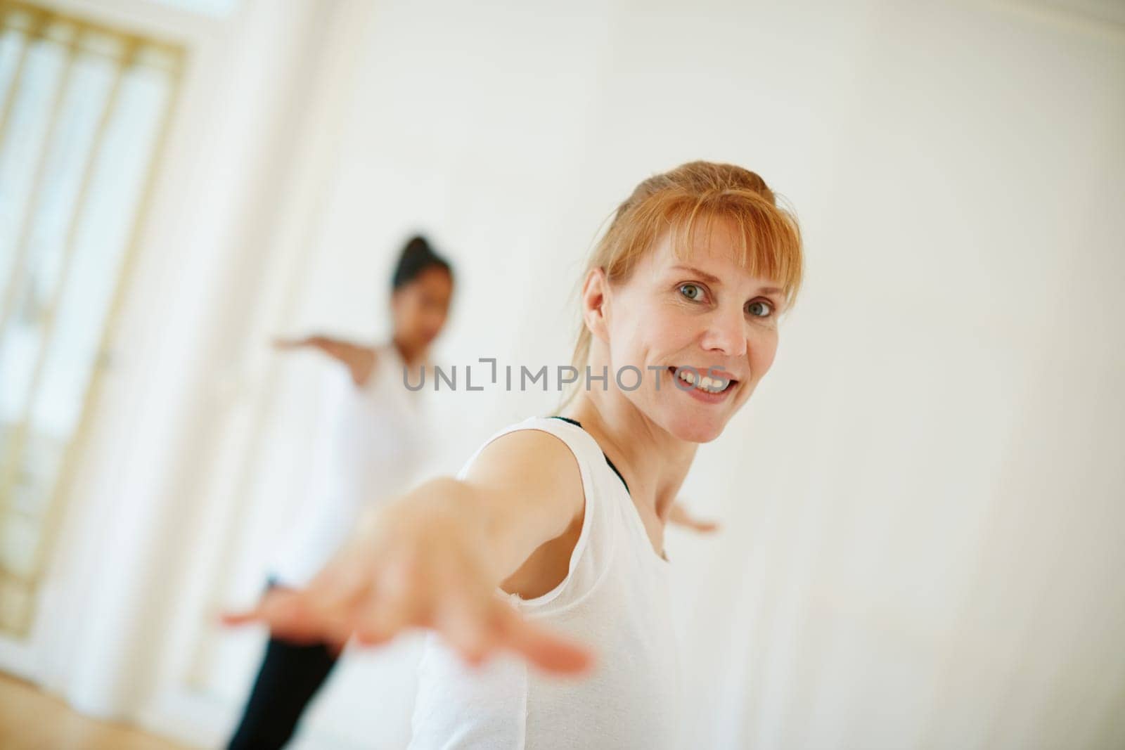 Yoga keeps her body flexible and strong. a woman doing a yoga class. by YuriArcurs