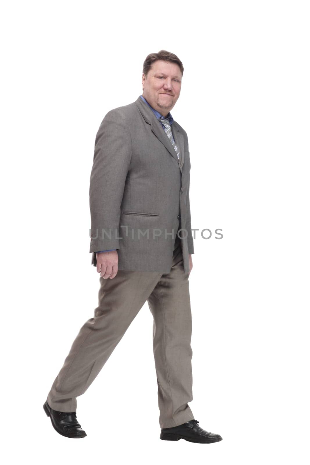full-length. casual man in a grey jacket striding forward. isolated on a white background.