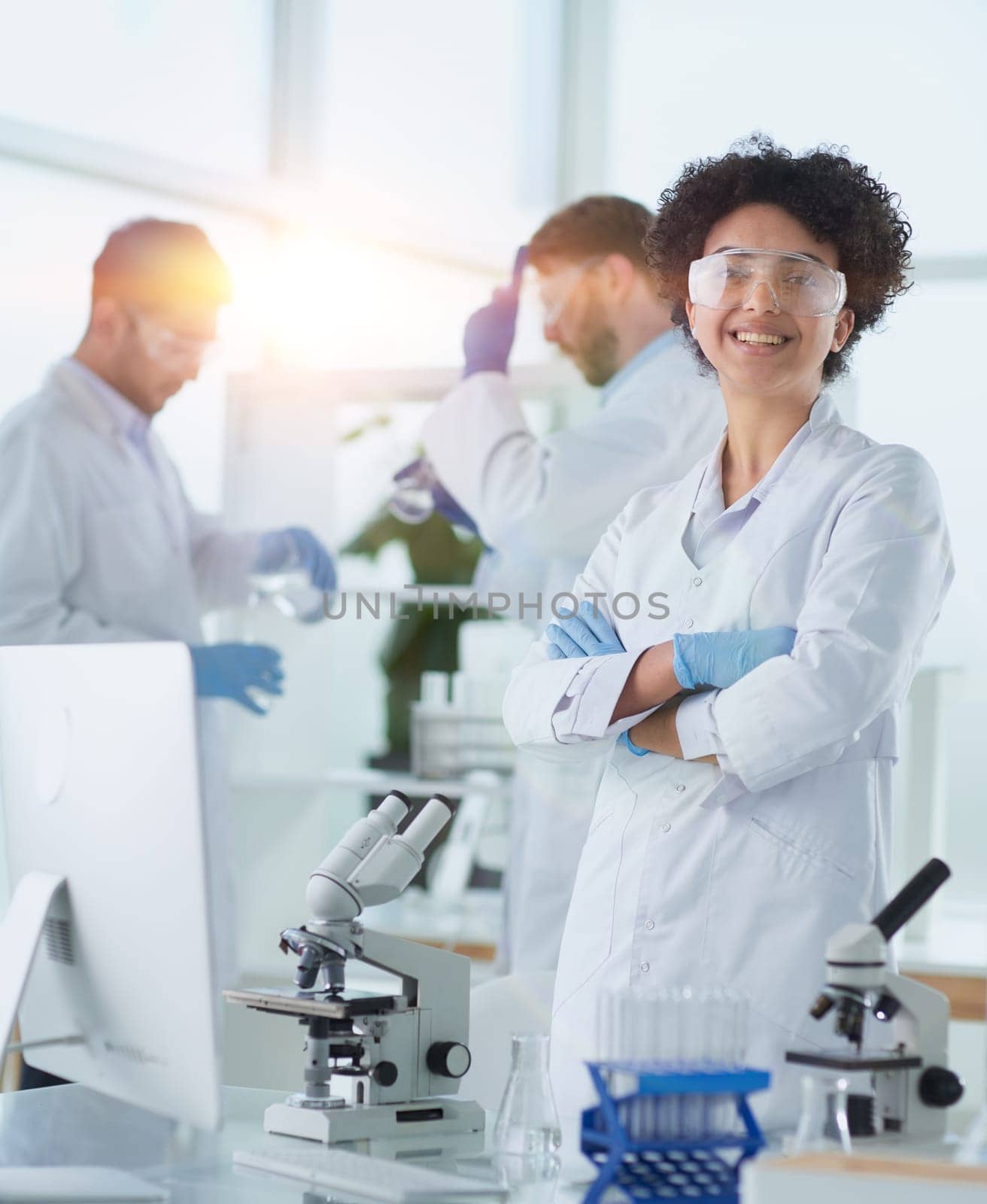 Smiling scientists looking at camera arms crossed in laboratory by asdf