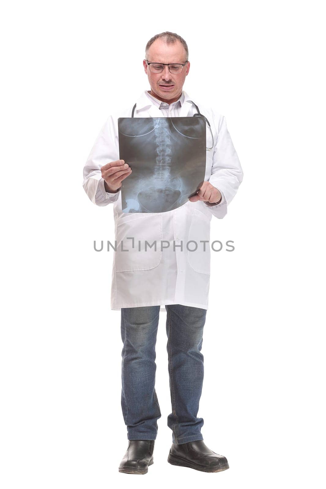 Front view of a doctor with stethoscope studying x-ray image. Isolated on white background