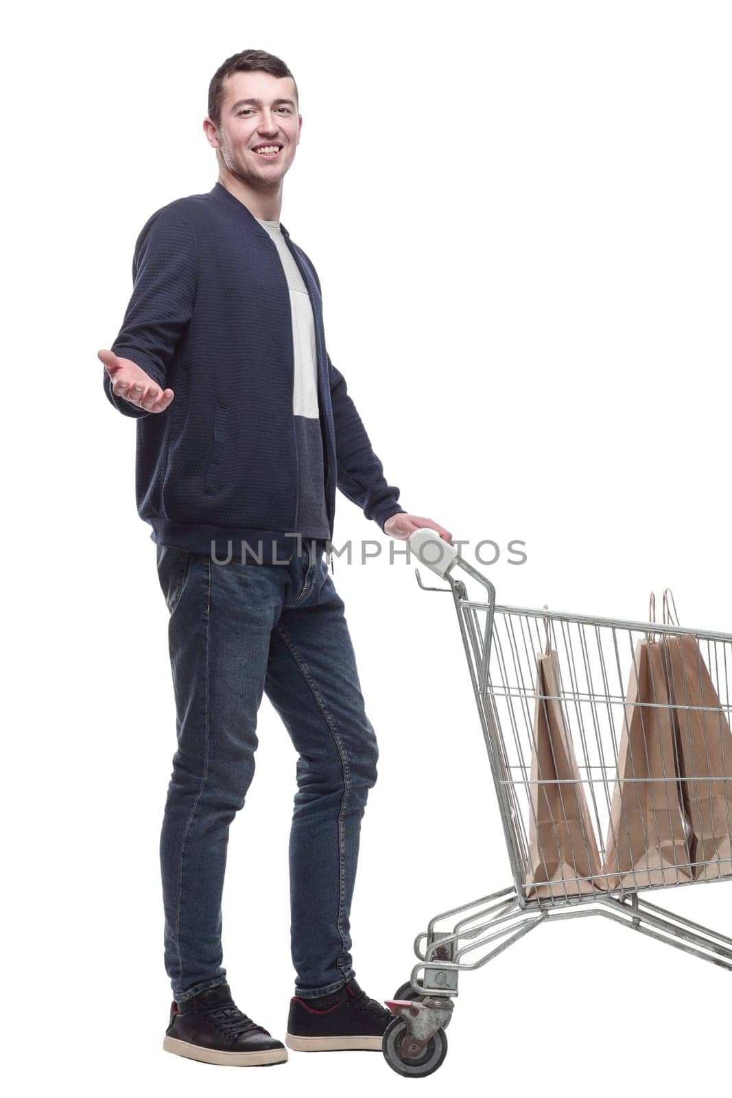 smiling young man with a shopping cart . isolated on a white background.