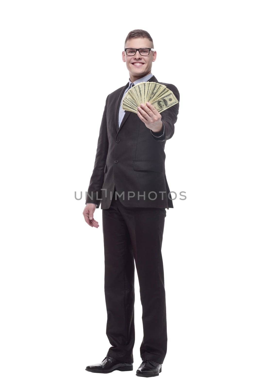 in full growth. happy young businessman with cash banknotes. isolated on a white background.