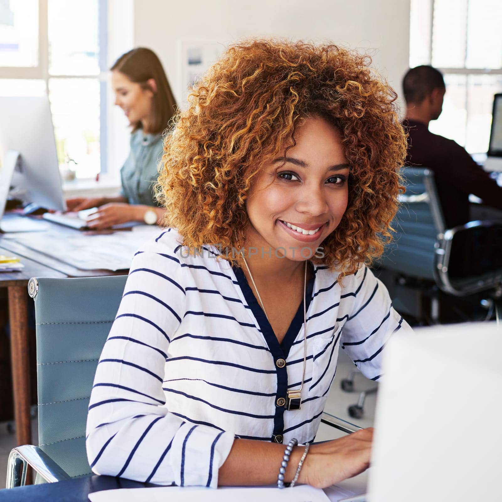 Portrait of black woman in creative agency with smile, confidence and success at design startup. Happy designer in modern office, manager or team leader working at laptop desk with digital technology by YuriArcurs