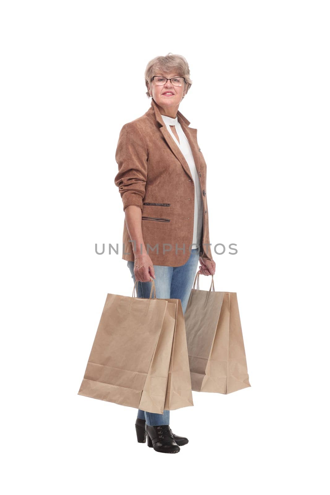 Full length portrait of a Senior woman walking with shopping bags and smilimg