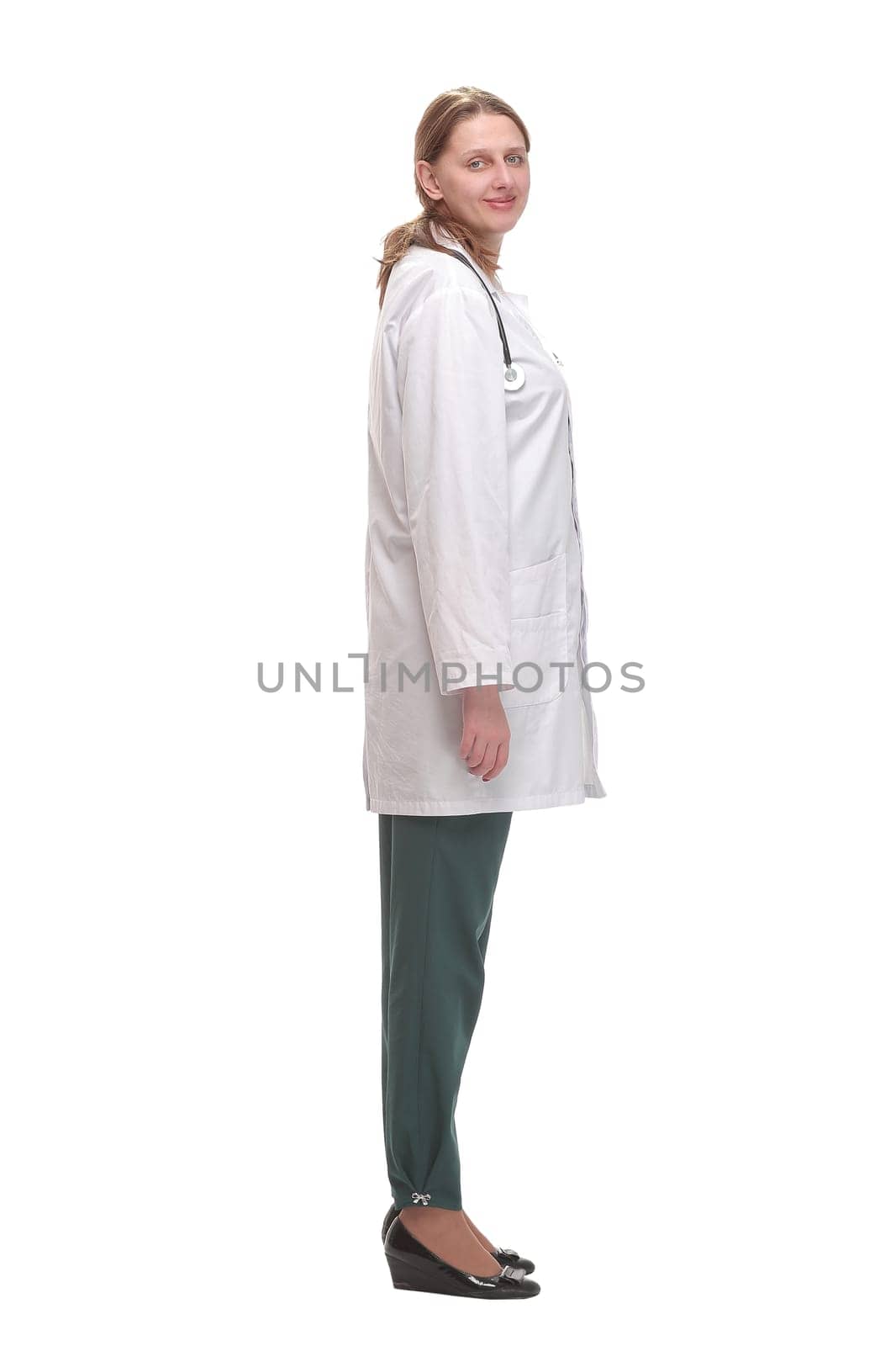 Side view of young female doctor or nurse standing over white background thoughtfully and looking forward.