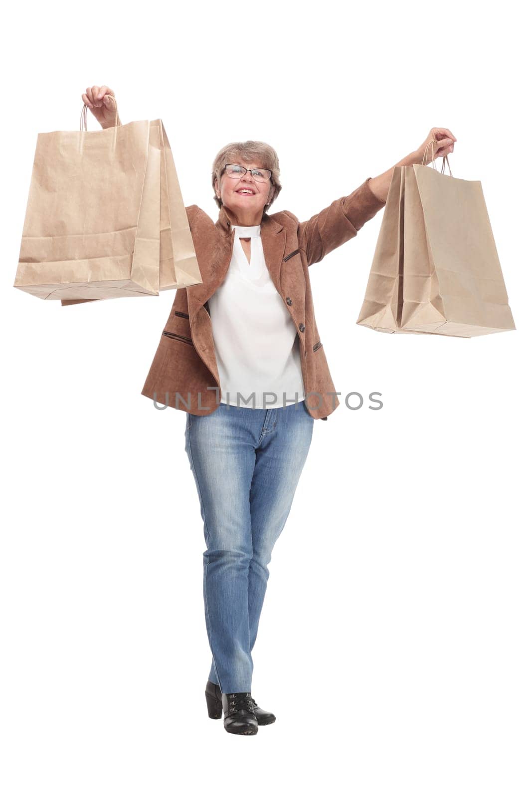 Mature woman holding bags smiling and looking at camera isolated over white background