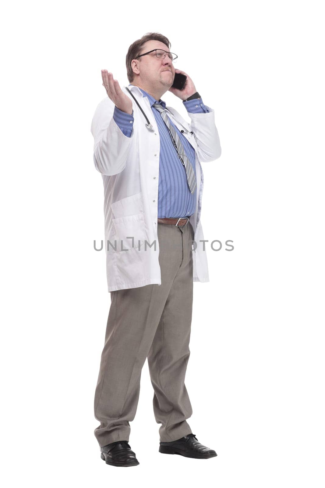 in full growth. qualified doctor with a smartphone.isolated on a white background.