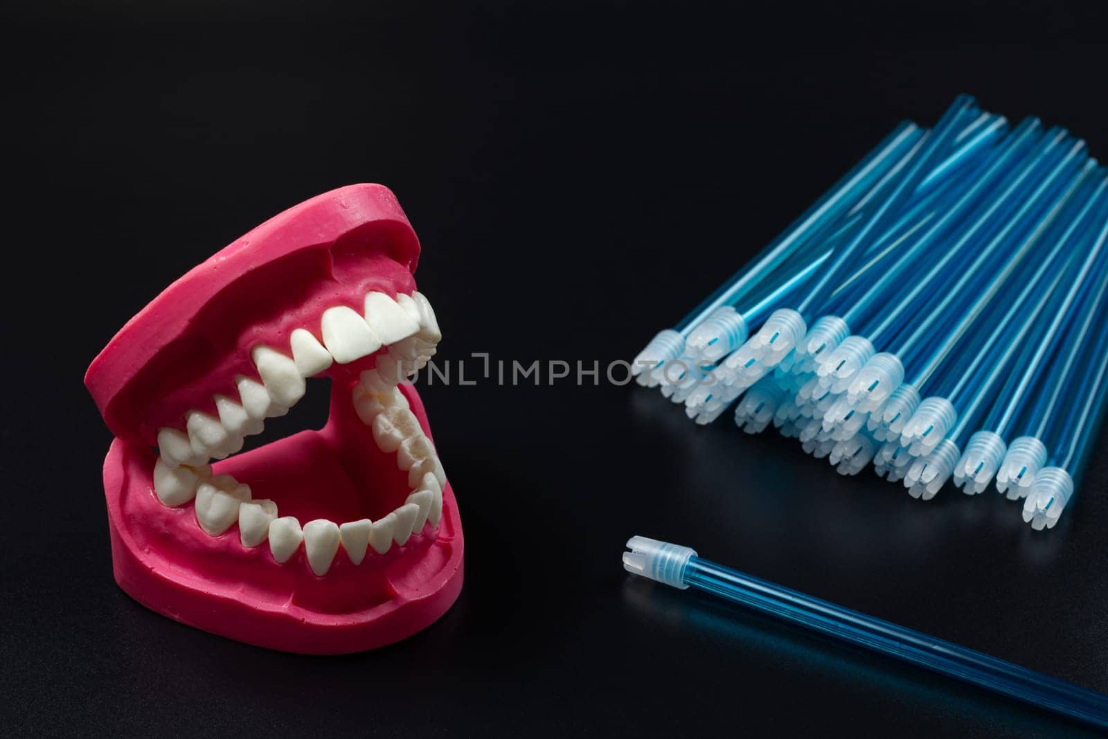 Human jaw layout with saliva ejectors on the black background. by mvg6894