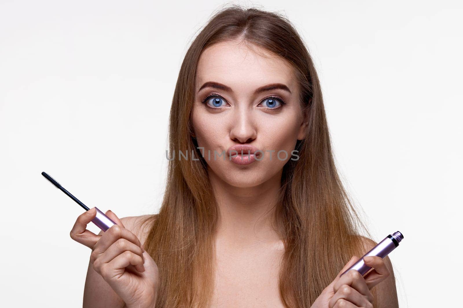 charming funny young woman hold mascara isolated on white background