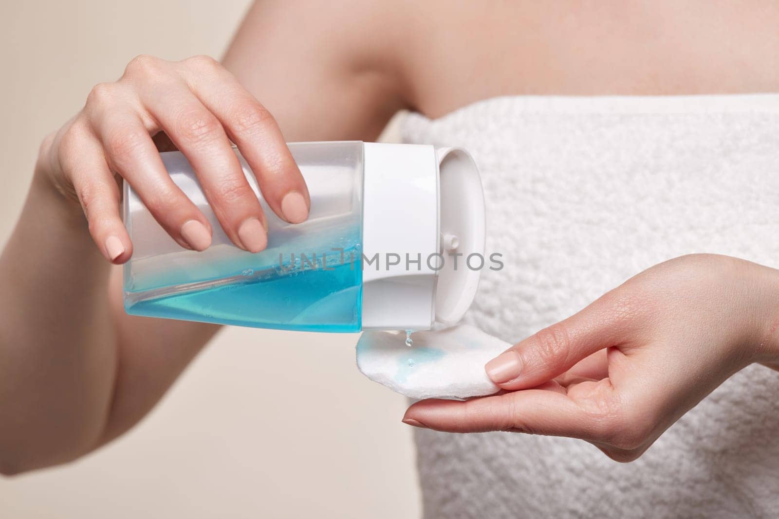 Close-up, female hands using toner and cotton pad to remove makeup