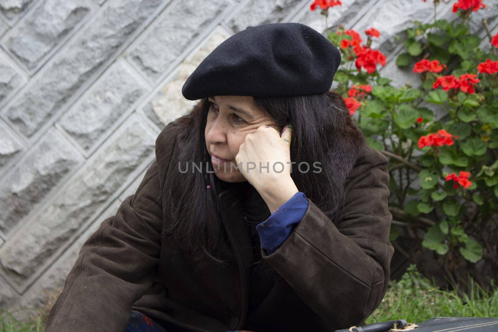 female painter sitting on the street bored and frustrated by her work. High quality photo
