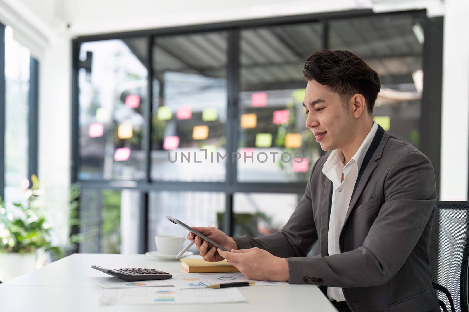 Businessman using digital tablet computer in office. Happy entrepreneur small business owner..